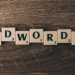 Scrabble tiles spelling 'AdWords' on a wooden surface, symbolizing digital marketing concepts.